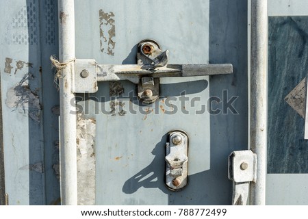 Closeup view of the worn door handle lock of an intermodal shipping container.