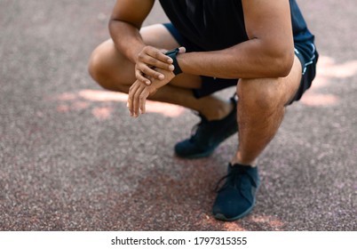 Closeup view of young black jogger checking smartwatch during his morning workout - Shutterstock ID 1797315355