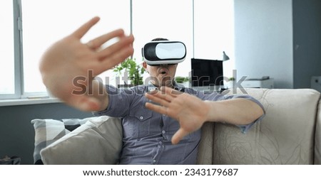 Close-up view of young man watching realistic picture in virtual reality headset