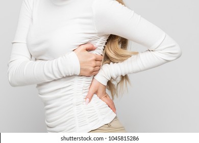 Closeup view of young woman having pain, 
muscle or chronic nerve pain in her back after working/Health Issue, diseases of the musculoskeletal system concept/Diseases of spine, scoliosis, osteoporosis