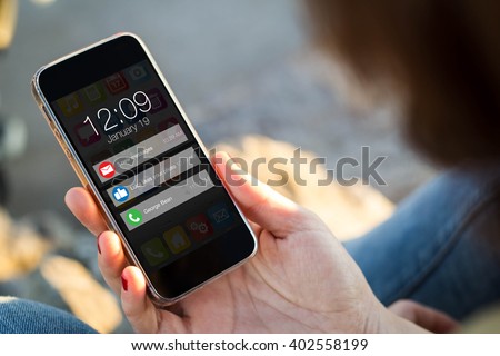 close-up view of young woman looking at notifications on her mobile phone. All screen graphics are made up.