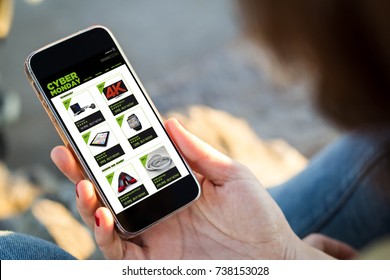 close-up view of young woman shopping on cyber monday on her mobile phone. All screen graphics are made up.
