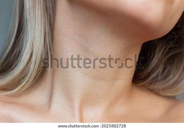 A close-up view of a young woman\'s\
neck and collarbone . Lines on the neck. Wrinkles, age-related\
changes, rings of Venus, goosebumps. Skin care.\
Close-up