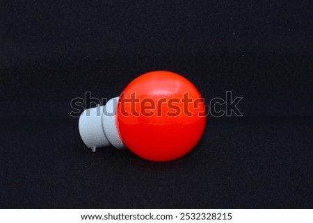 Close-up view of a zero wattage bulb orange-red colored on a black background