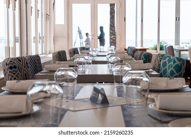 Close-up Views To The Interior Of An Empty And Closed Restaurant, With The Tables Prepared With Cutlery, Crockery And Glasses. 