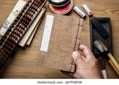 Closeup vintage style of Japanese stab binding in hand. Reading a book. - Shutterstock ID 667958938