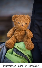 Closeup of vintage teddy bear on backback in the street 
