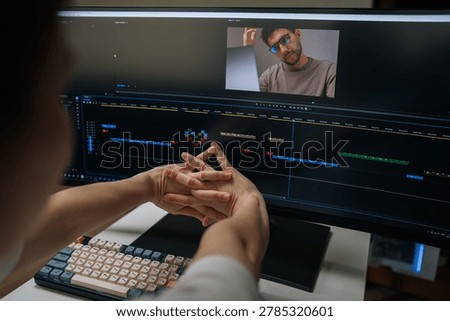 Close-up of visual editor stretching hands and resting from intense video editing work, showing digital creator feeling tired working on computer workstation with timelines and footage on screen.