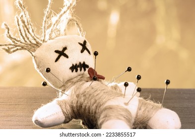 Close-up of a voodoo doll, needles stuck in it. - Shutterstock ID 2233855517