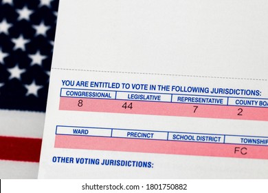 Closeup Of Voter Registration Identification Card With American Flag In Background. Concept Of Right To Vote, Voter Suppression And Election