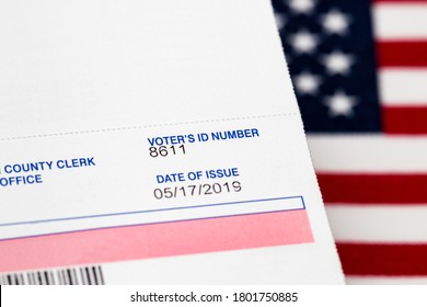 Closeup Of Voter Registration Identification Card With American Flag In Background. Concept Of Right To Vote, Voter Suppression And Election