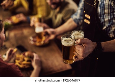 Close-up of waiter serving beer to customers in a pub.  - Powered by Shutterstock