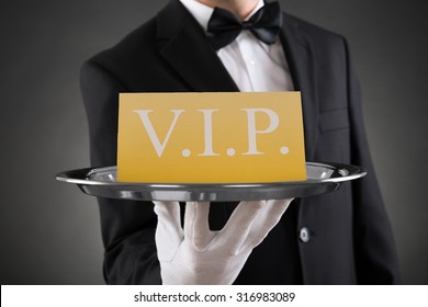 Close-up Of Waiter Showing Vip Text On Banner