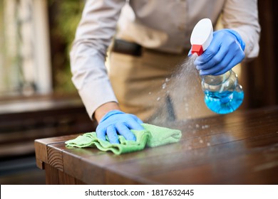Close-up of waitress cleaning tables with disinfectant due to coronavirus epidemic. 
