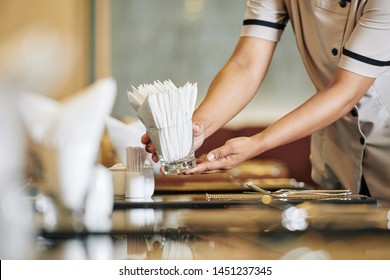 Close-up of waitress setting the table in the restaurant she putting the napkins on the table - Powered by Shutterstock