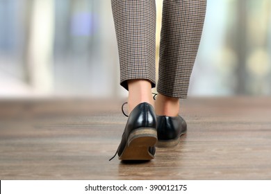 Close-up Of  Walking Woman Feet In Black Shoes On The Floor