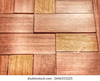 A close-up of a wall constructed from rectangular wooden blocks, arranged symmetrically to form a pattern similar to bricks. It showcases warm natural wood grain and tones, ideal for background 