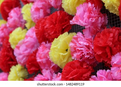 Closeup Of Wall Of Crafted Tissue Paper Flowers (Pink, Yellow, And Red)