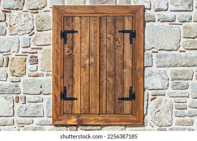 Close-up wall of a stone house with wooden windows and shutters. Old european architecture - Powered by Shutterstock