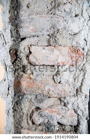 A close-up of a wall with stripped plaster and uncovered brickwork. Renovation of a house, a flat.