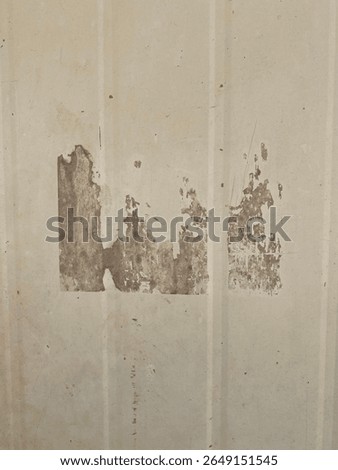 Close-up of wall surface with leftover adhesive marks after wallpaper removal. The glue stains and uneven texture give a raw, damaged look—ideal for restoration.