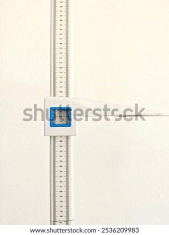 Close-up of a wall-mounted height measuring scale in a medical or clinical setting