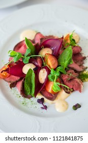 Close-up Of A Warm Salad With Roast Beef. Cherry Pickers, Basil, Sauce, Spices. Very Tasty, Lunch, Dinner. Beautiful Feed. View From Above