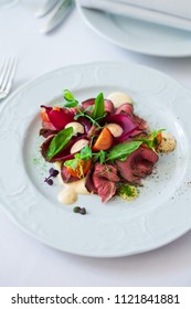 Close-up Of A Warm Salad With Roast Beef. Cherry Pickers, Basil, Sauce, Spices. Very Tasty, Lunch, Dinner. Beautiful Feed. View From Above