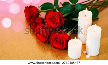 A close-up, warm-toned image featuring five velvety deep red roses laid diagonally across a textured, shimmering gold surface. Three white pillar candles of varying heights are lit beside the roses, c