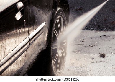 Closeup Of Washing Car With Pressure Washer