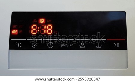 Close-up of a washing machine control panel with a digital display and a error code E18. The red LED screen shows the washing time and temperature settings. Home appliance concept.