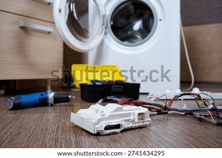 Close-up of washing machine control unit. Washing machine electronic module replacement. Home appliance diagnostics and repair.