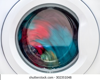 Closeup Of Washing Machine Door With Spinning Laundry