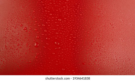 A close-up of water droplets forming on a smooth red surface, creating a refreshing and textured background. This high-quality stock image is ideal for branding, marketing materials, creative digital