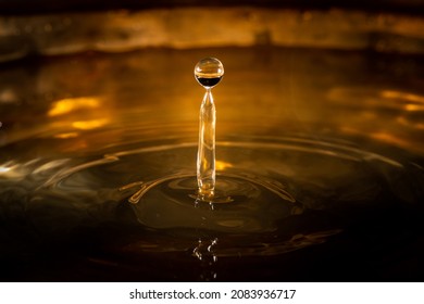 Closeup Of A Water Droplets Hitting The Surface, Dark, Bronze Background