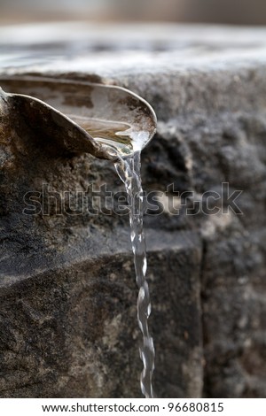 Closeup of water running from outdoor wall faucet