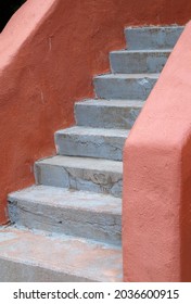 Closeup Of Weathered Concrete Stairs With Orange Stucco Adobe Walls