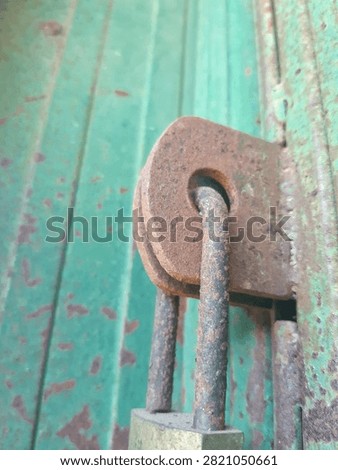 Close-up of a weathered, corroded padlock locking a rustic green metal rolling shutter or garage door, showing strong rust textures.