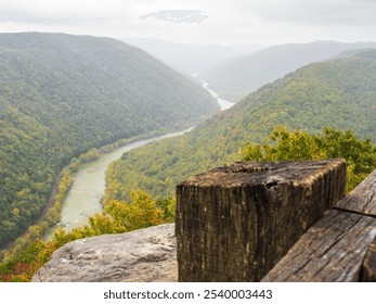 A close-up of a weathered fence post at Turkey Spur Rock and Grandview Rim in New River Gorge National Park, West Virginia, framed by the misty mountains fading softly in the distance. - Powered by Shutterstock