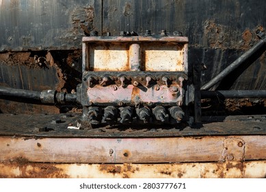 Close-up of a weathered mechanical control box mounted on the preserved JDŽ 85-045 narrow gauge steam locomotive in Užice, Serbia. Detailed view of industrial heritage featuring rust, worn paint and aged metal textures.