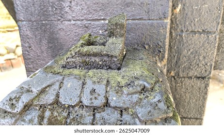 Close-up of a weathered, moss-covered stone carving, possibly part of a structure or monument in Purworejo, Indonesia. Ancient texture - Powered by Shutterstock - Get 15% off with code: PIKWIZARD15