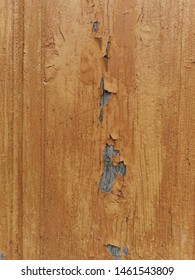 Closeup Of Weathered And Pealing Dull Gold Coloured Paint On Natural Wood Door