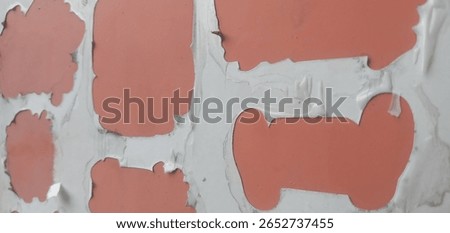 Close-up of a weathered stencil surface showing peeling orange paint and white background with various abstract shapes and patterns. Signs of wear and aging are clearly visible.

