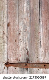 Closeup Of A Weathered Wood Barn Door With A Rusty Metal Hinge