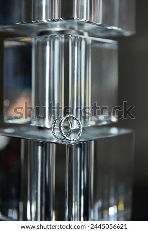 A close-up of wedding rings on a reflective surface