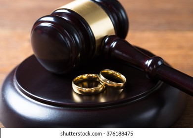 Closeup Of Wedding Rings On Wooden Mallet At Table In Courtroom