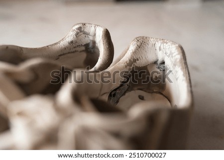 Close-up of well-used sneakers, highlighting the wear and tear, representing the underconsumption core trend focused on sustainability and mindful consumption