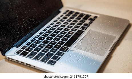 Close-up of a wet laptop keyboard with water droplets. - Powered by Shutterstock