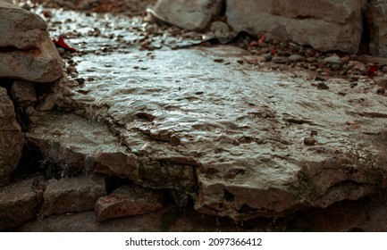 A Closeup Of The Wet Muddy Surface  Muddy Water With Rocks 