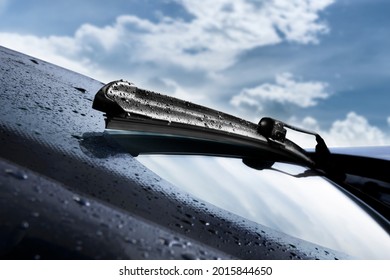 Closeup of wet windshield wiper, wipping windscreen outside